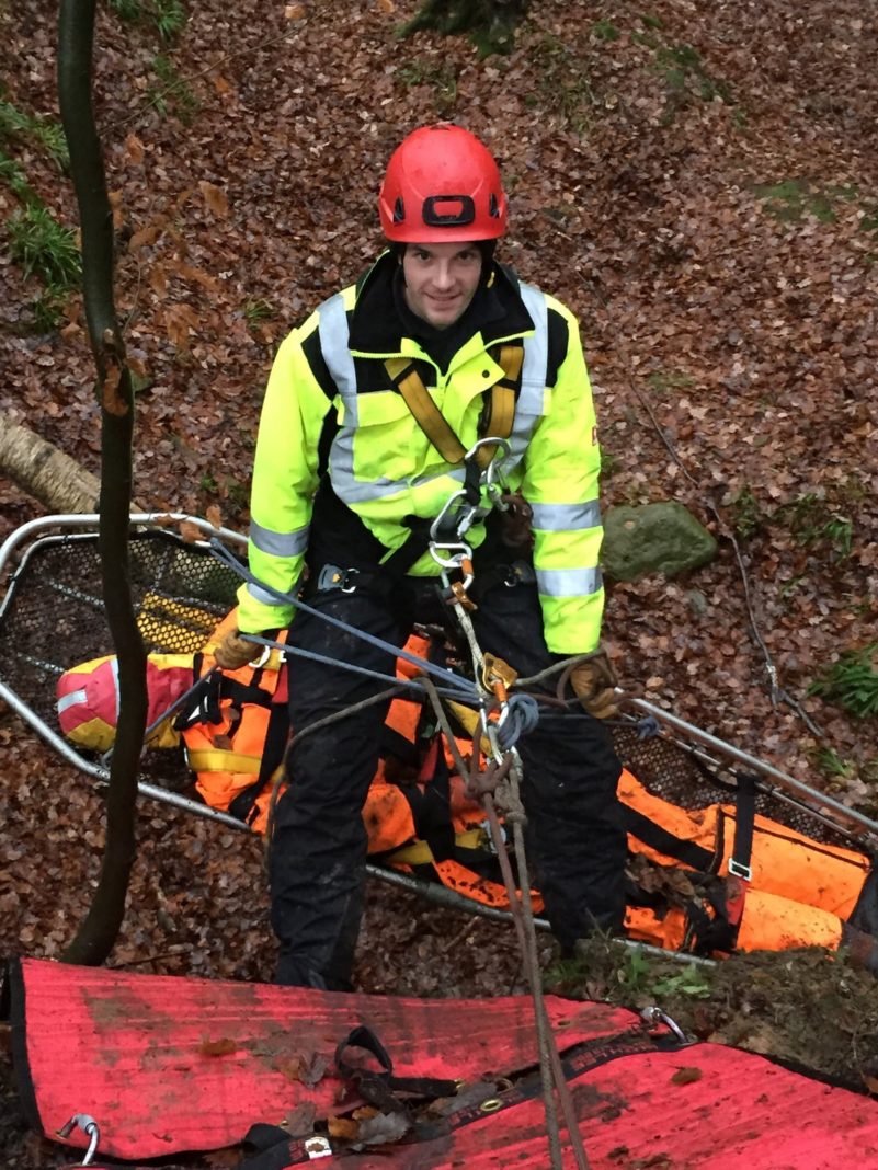 Rescue worker in safety gear conducting a forest operation.