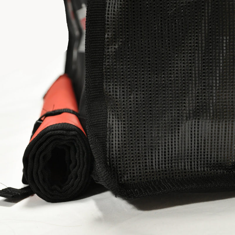 Rolled yoga mat beside black mesh bag.