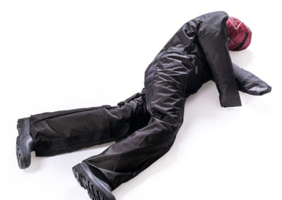 Rescue training dummy in black suit lying down.