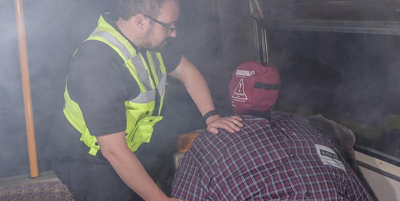Emergency responder assisting person in smoke-filled environment - Bariatric Rescue Training