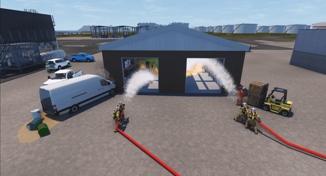Firefighters extinguishing fire in industrial warehouse simulation.