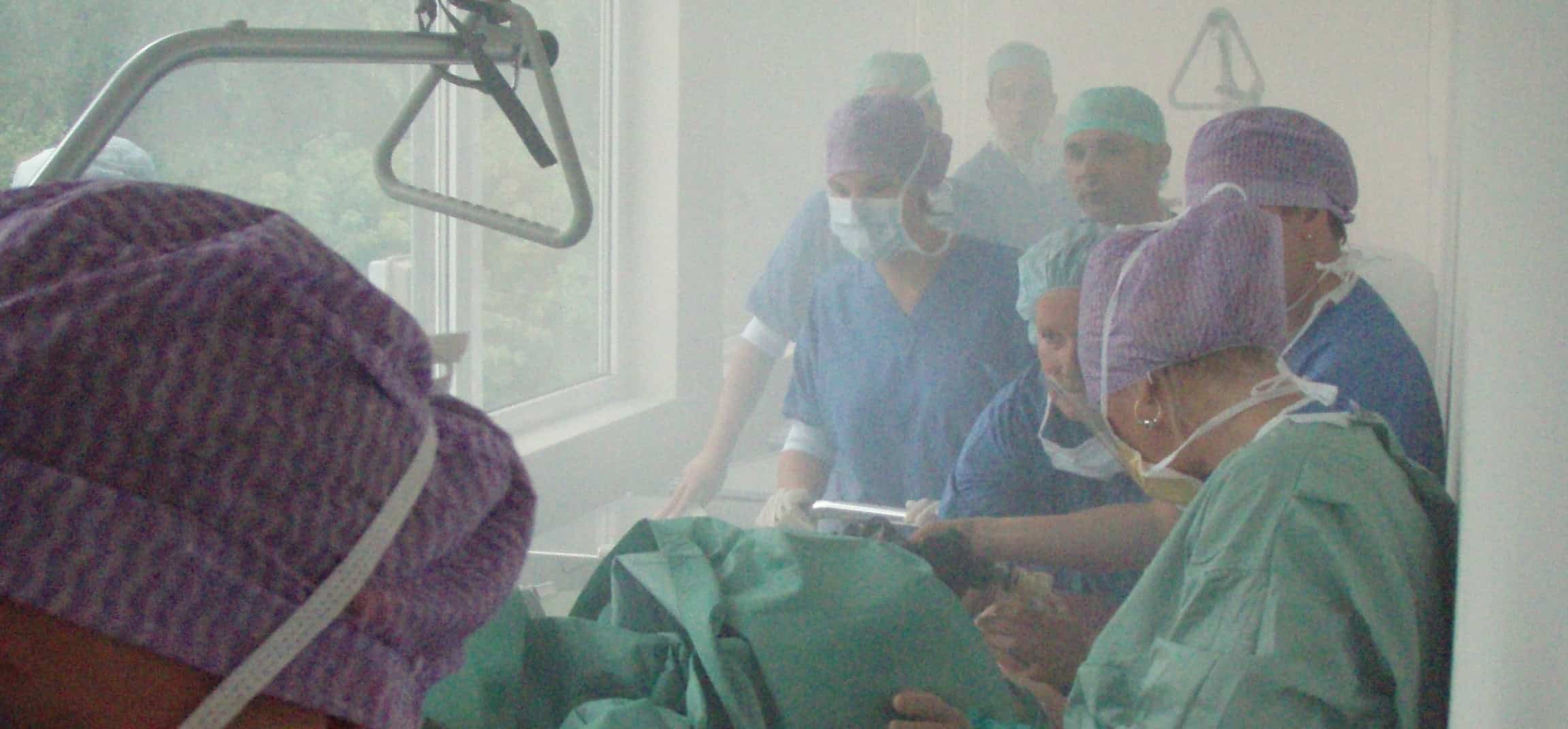 Doctors and nurses in an operating room with smoke