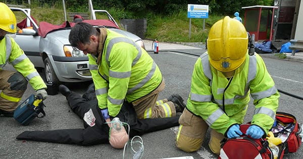 Firefighters performing CPR at a car accident scene