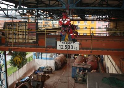 Industrial crane lifting materials in a warehouse facility.