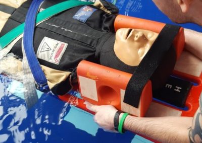 Water rescue training with mannequin in a pool.