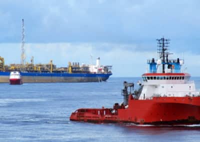 Offshore oil platform and tugboat at sea.