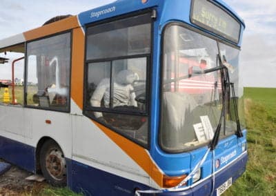 Multi Trauma Training Manikins - Crashed bus with broken window in a field.
