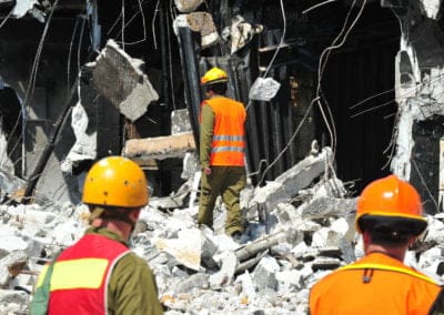 Construction workers inspect building rubble.