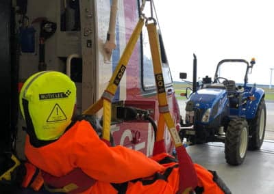 Rescue mannequin suspended inside helicopter for training.