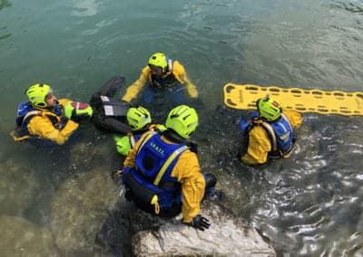 Rescue team training in water with dummy and stretcher.