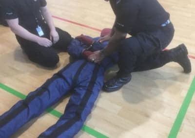 Police officers performing CPR training on a dummy.