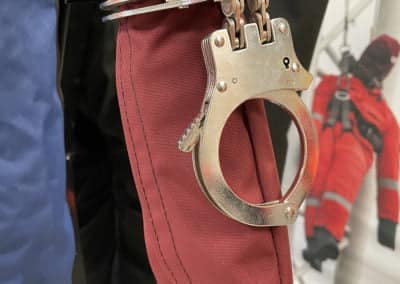 Handcuffs attached to red padded arm restraint.
