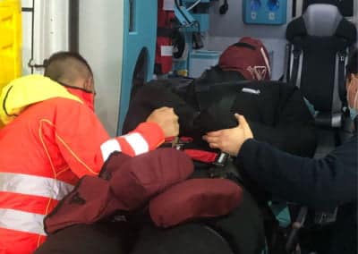 Paramedics assisting patient inside ambulance.
