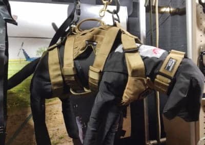 Dog mannequin in tactical harness display at trade show.