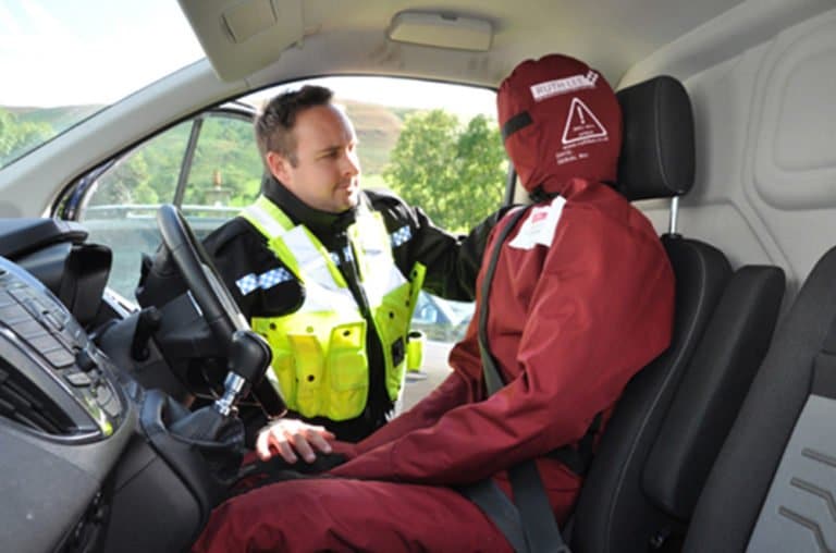 Police man with duty training manikin driver seat