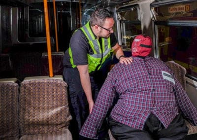 Train worker assisting safety training with a dummy.