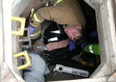 Firefighter rescuing a person from a confined space.