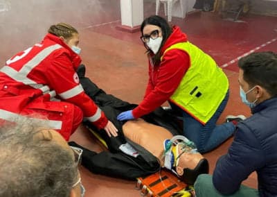 First aid training with CPR practice on a mannequin.