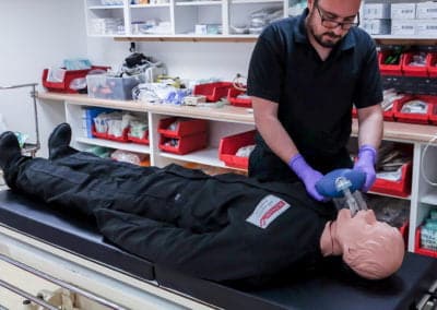 Instructor demonstrating CPR on a medical mannequin.