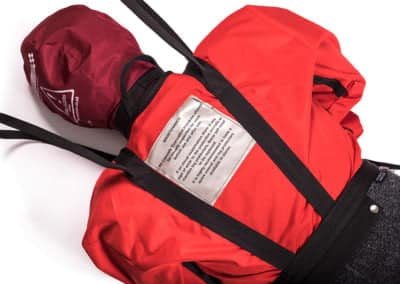Rescue training manikin in red with instructional label.