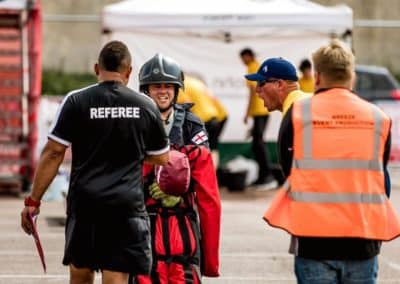 Referee with firefighter at outdoor sports event.