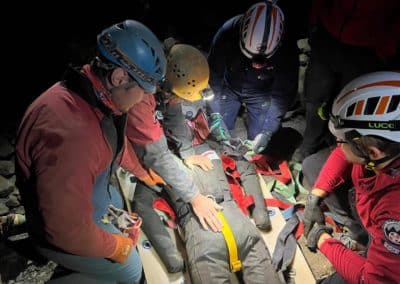 Rescue team helping injured person underground.