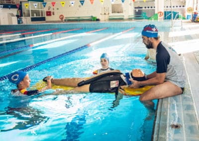 Lifeguard training session with a CPR dummy in pool.