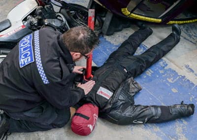 Police officer assisting an injured motorcyclist.