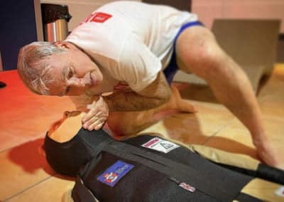 Man practising CPR on a dummy.