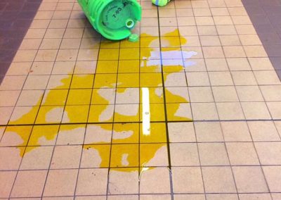 Spilled liquid from green container, safety hazard on floor.