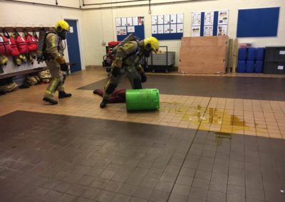 Firefighters in training exercise with spill and dummy.