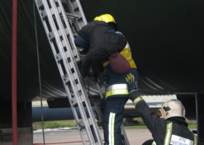 Firefighters climbing ladder during emergency response training.