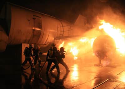 Firefighters extinguishing a plane fire at night.
