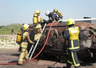 Firefighters conducting rescue operation on overturned tank.