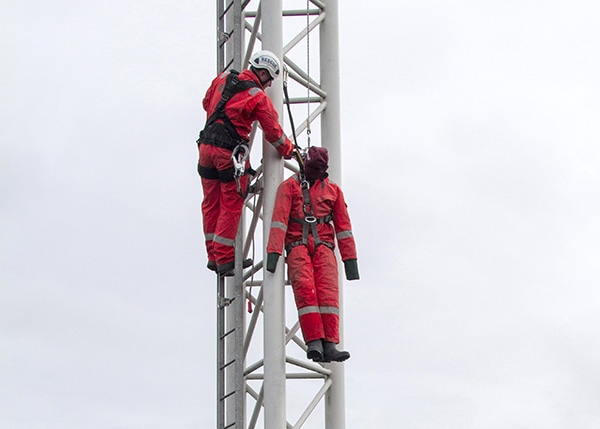 Worker rescuing dummy from high structure.