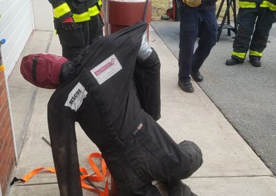 Firefighters conducting a training exercise with a rescue dummy.