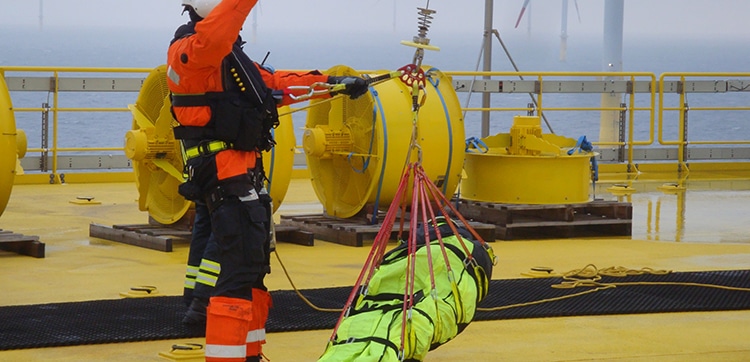 Offshore rescue training exercise with safety equipment.