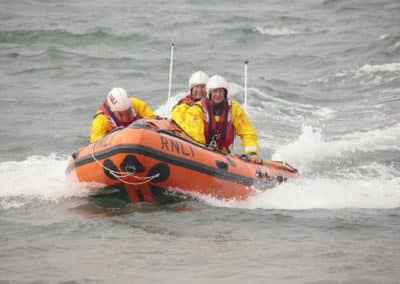 Rescue lifeboat with crew on rough sea.