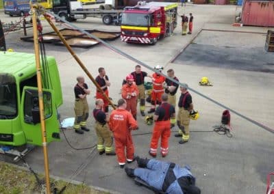 Firefighters conducting a rescue training exercise near green truck.
