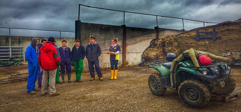 Group discussing on farm next to quad bike.