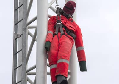 Worker in safety gear practicing fall protection rescue.