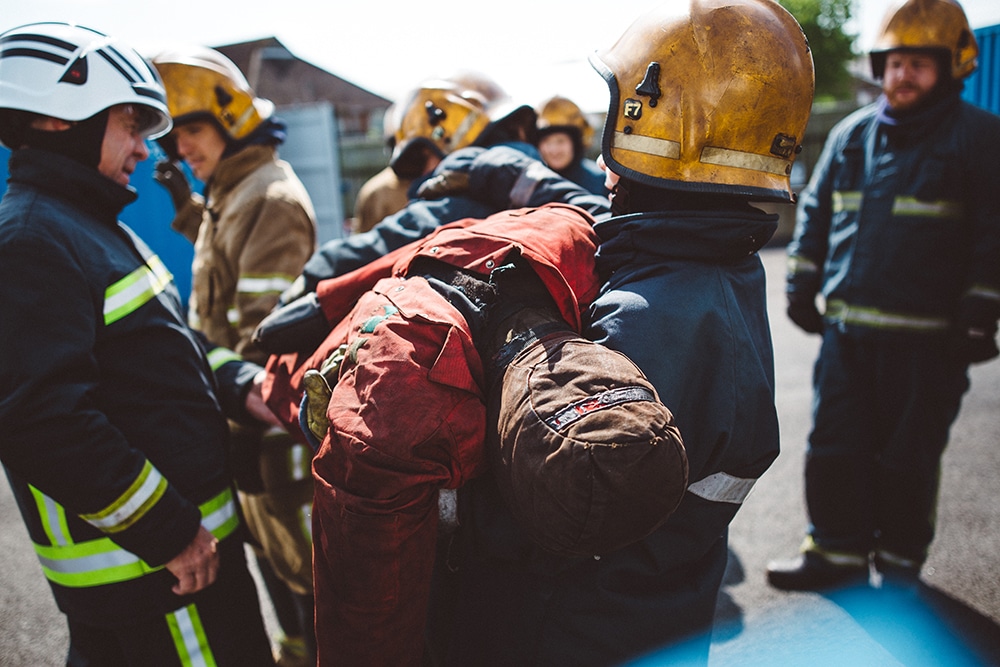 Firefighters in training exercise carrying a dummy.