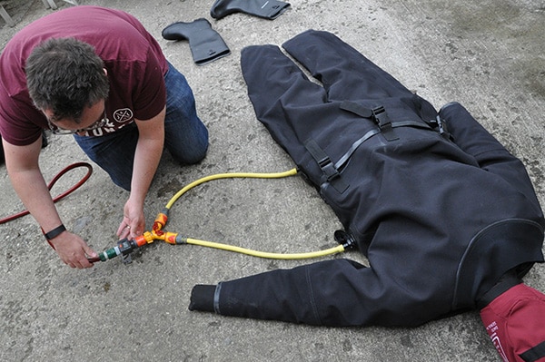 Inflating a drysuit with air hose.