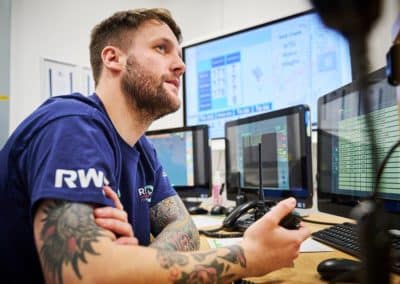 Person monitoring screens in an ops control room.