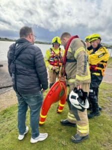 Firefighters discuss rescue plan near water with new FReD Fast Rescue Device.